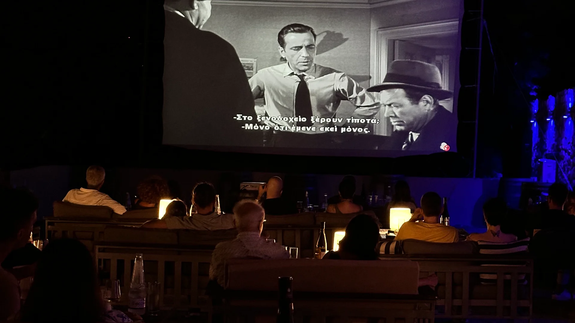 Rows of couches facing the screen, with small tables and lamps