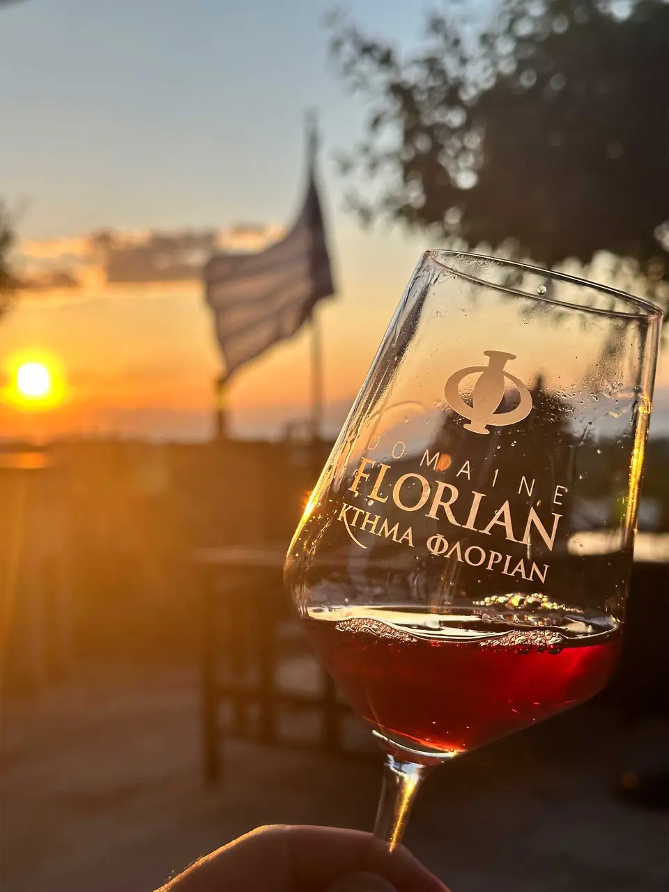Ein Glas mit der Gravur „Domaine Florian“ vor der untergehenden Sonne